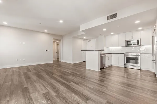 a kitchen with stainless steel appliances granite countertop a refrigerator and a stove