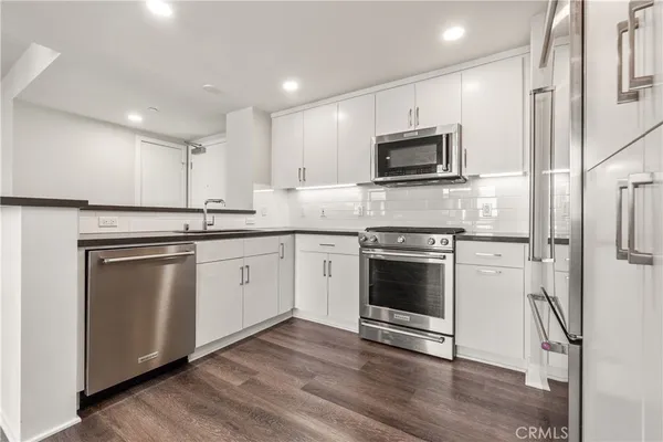 a kitchen with stainless steel appliances granite countertop a refrigerator and a sink