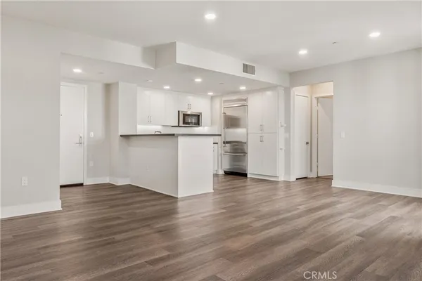 an empty room with wooden floor and natural light
