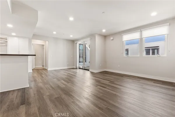 a kitchen with cabinets stainless steel appliances and wooden floor