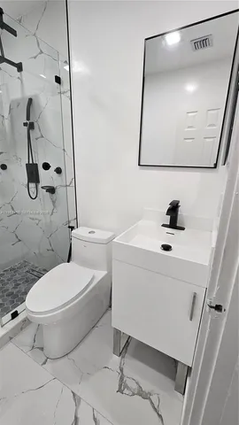 a white toilet sitting next to a bathroom sink
