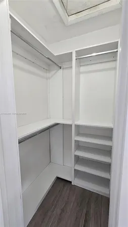 a view of walk in closet with empty racks