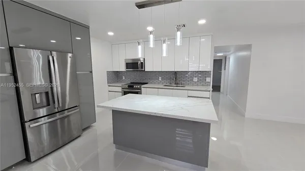 a kitchen with stainless steel appliances granite countertop a refrigerator and a stove
