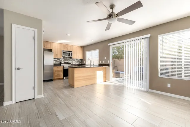 an empty room with fan and windows