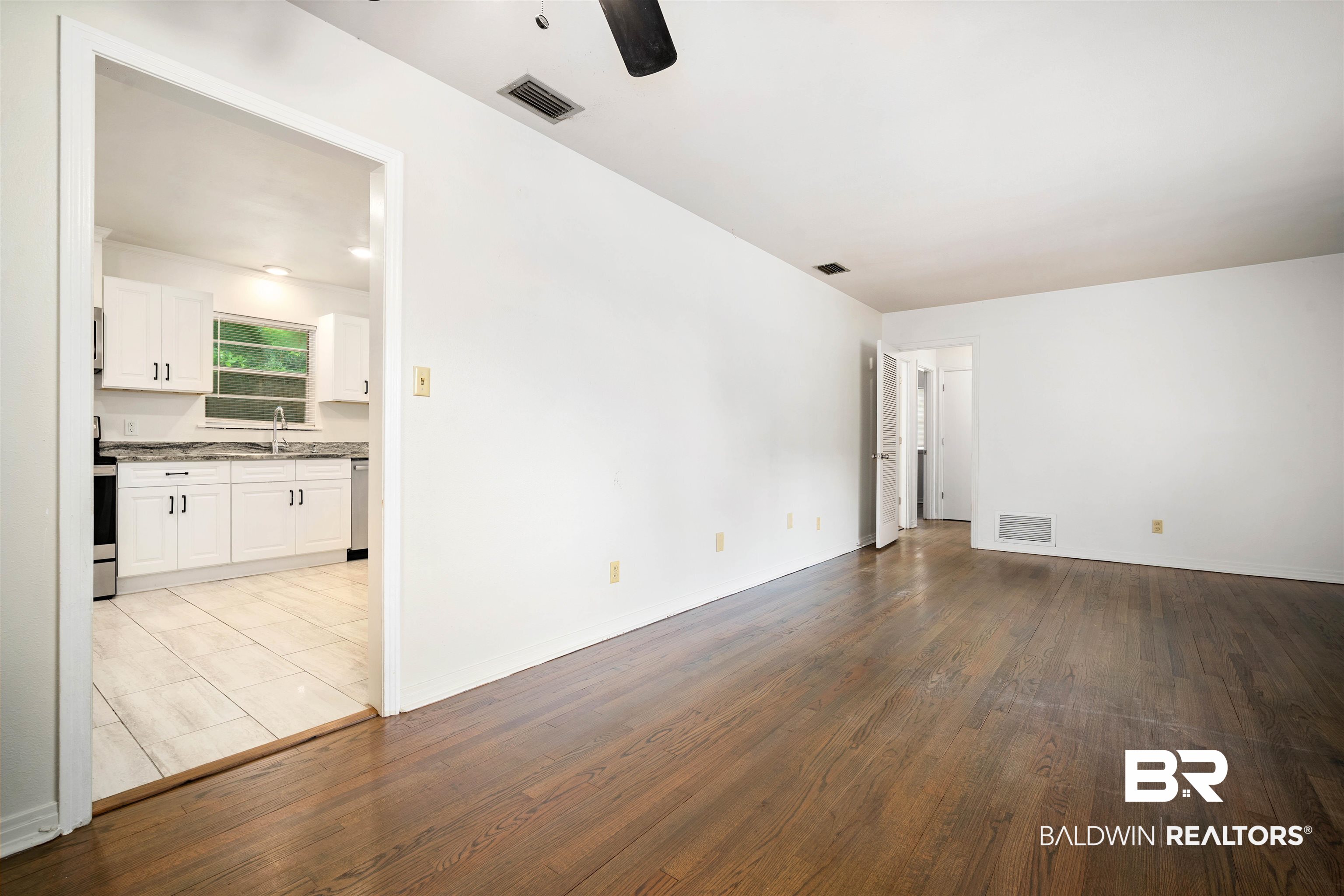 570 Markham Drive Mobile, AL 36609 - Photo 13 of 25 Spare room with wood finished floors, visible vents, a sink, and ceiling fan
