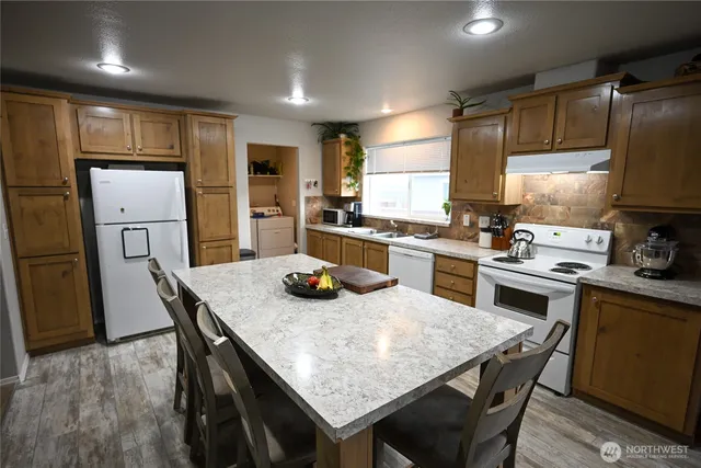 a kitchen with refrigerator cabinets dining table and chairs
