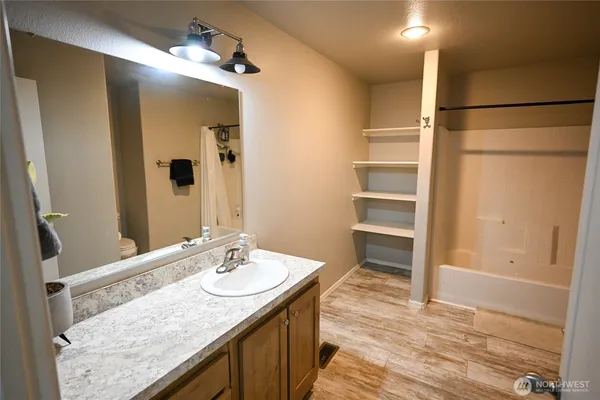 a bathroom with a granite countertop sink mirror and a shower