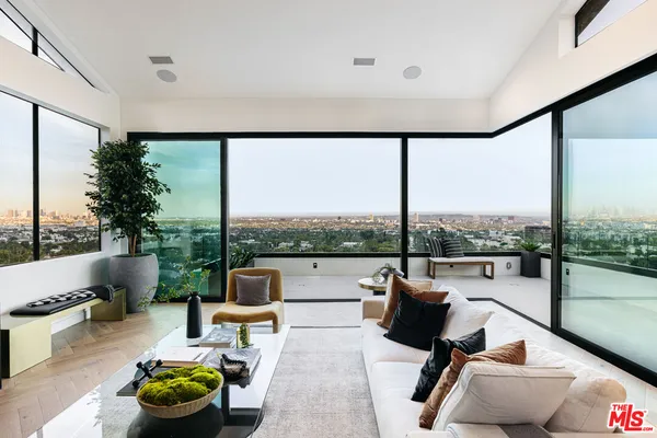a living room with patio furniture and a floor to ceiling window