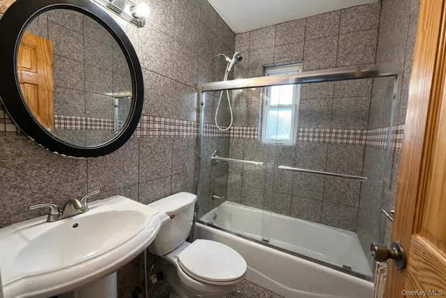a bathroom with a sink a toilet and a mirror