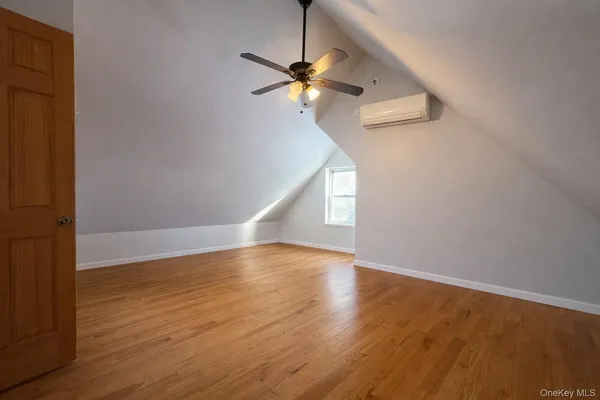 a view of a room with wooden floor ceiling fan and window