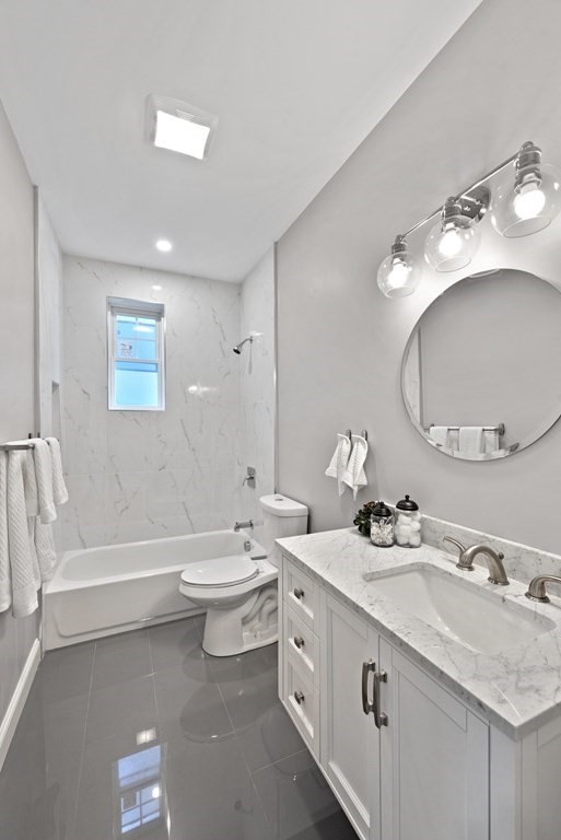 68 Edson Street, Unit 1 Boston, MA 02124 - Photo 17 of 23 a bathroom with a double vanity sink double mirror bathtub and toilet