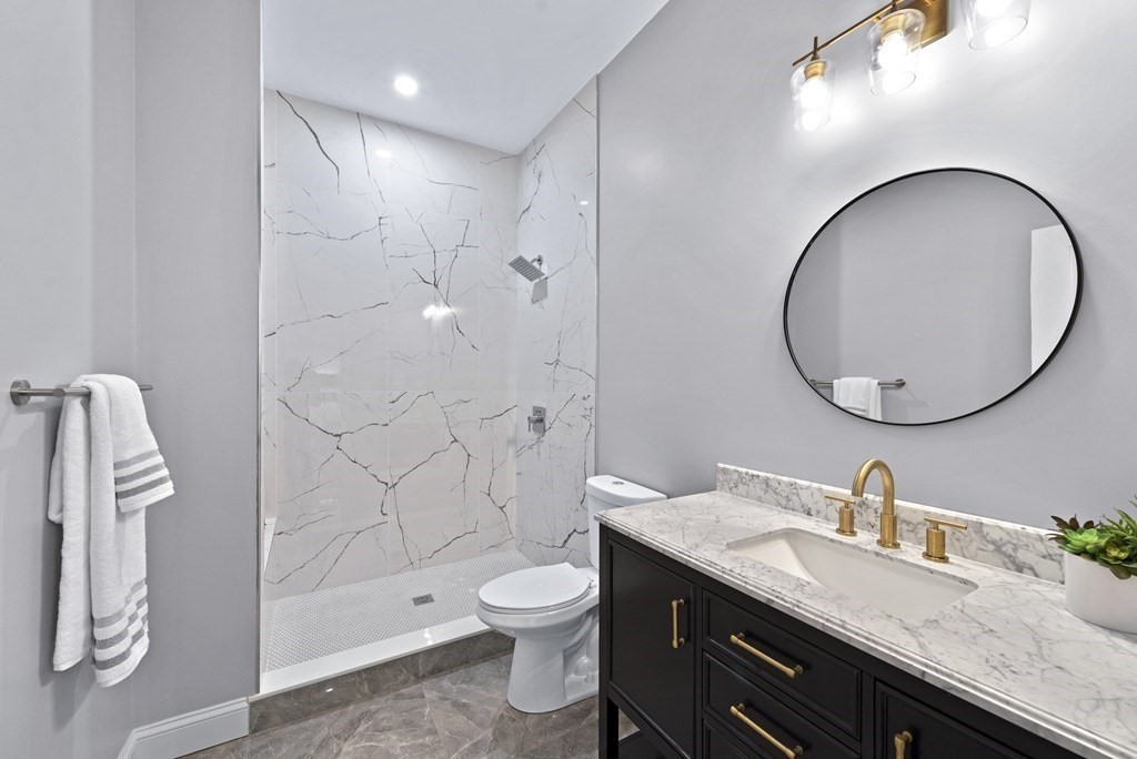 68 Edson Street, Unit 1 Boston, MA 02124 - Photo 19 of 23 a spacious bathroom with a granite countertop bathtub sink mirror and toilet