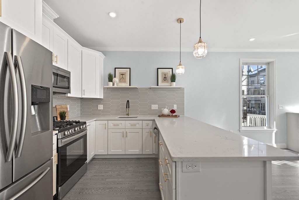 68 Edson Street, Unit 1 Boston, MA 02124 - Photo 5 of 23 a kitchen with granite countertop a sink stainless steel appliances and cabinets