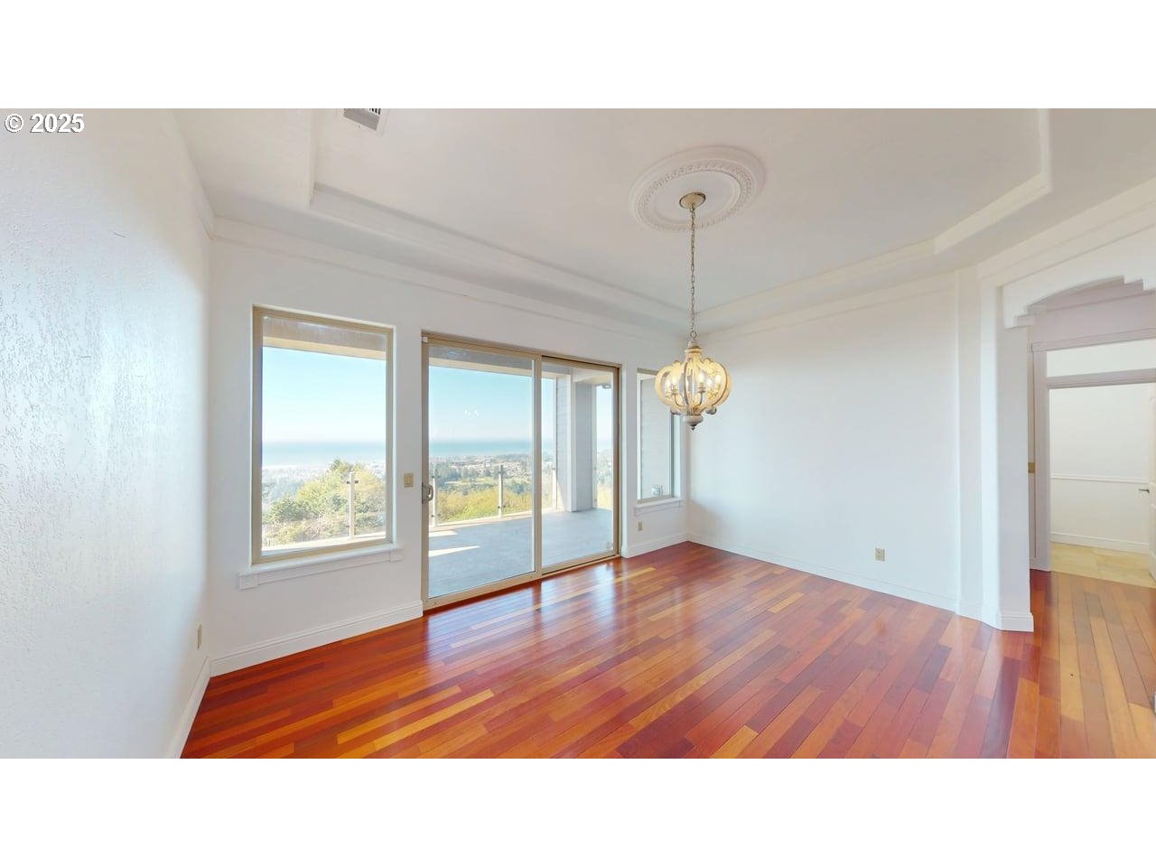 16898 Crown Terrace Brookings, OR 97415 - Photo 12 of 42 a open hall with a hardwood floor and a ceiling fan