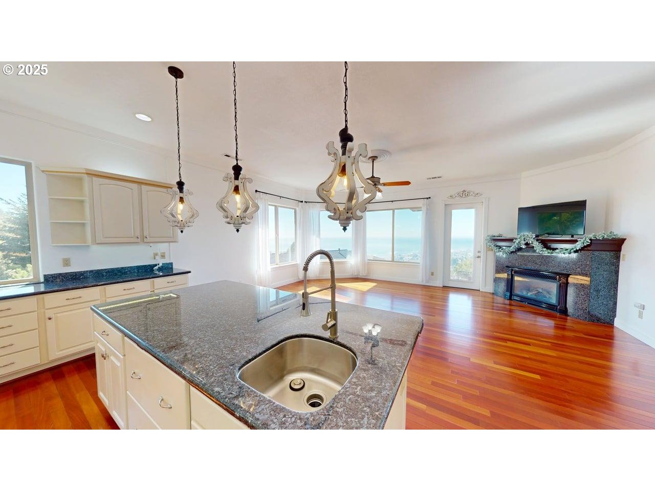 16898 Crown Terrace Brookings, OR 97415 - Photo 10 of 42 a kitchen with kitchen island granite countertop a sink a counter top space and living room view