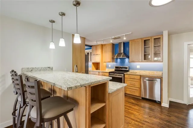 a kitchen with a stove a sink a counter space and wooden floor