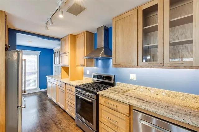 a kitchen with a stove and a wooden floor