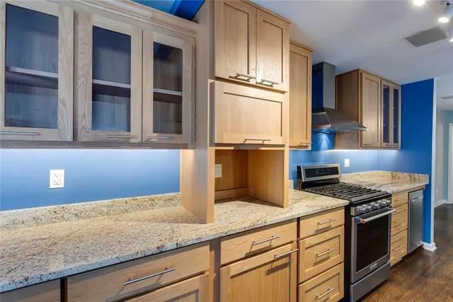 a kitchen with granite countertop cabinets stainless steel appliances and a counter space