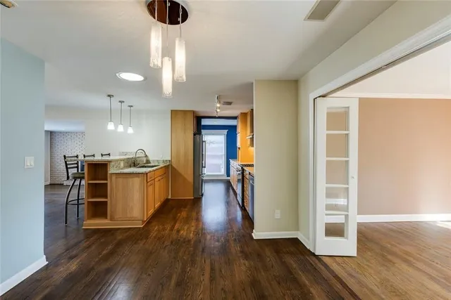 a kitchen with a refrigerator and wooden floor