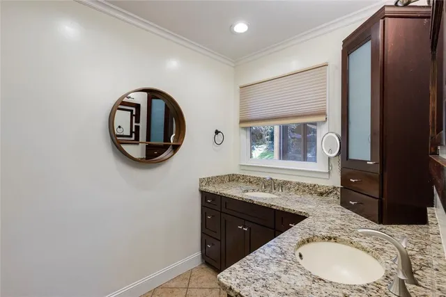 a bathroom with a granite countertop sink vanity mirror and toilet