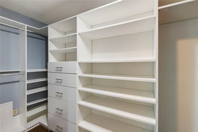 a view of walk in closet with empty racks