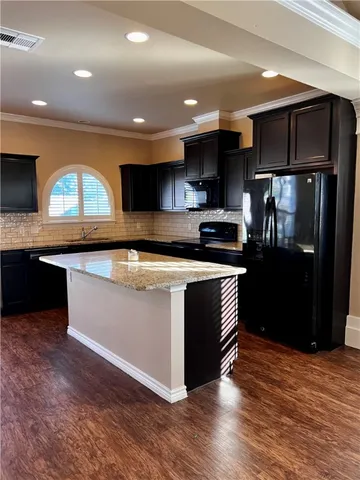 a kitchen with stainless steel appliances granite countertop a stove a sink and a refrigerator