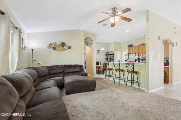 a living room with furniture and kitchen view