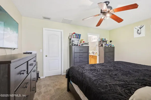 a spacious bedroom with a bed and a chandelier