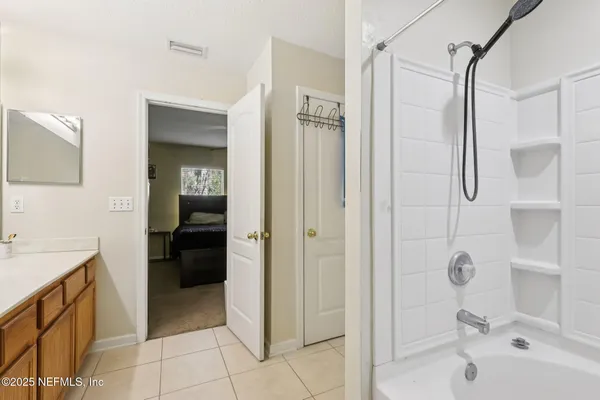 a bathroom with a granite countertop sink a mirror and shower