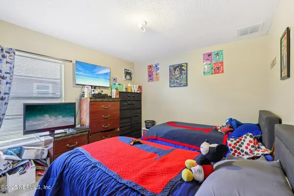 a bedroom with two beds and a flat screen tv