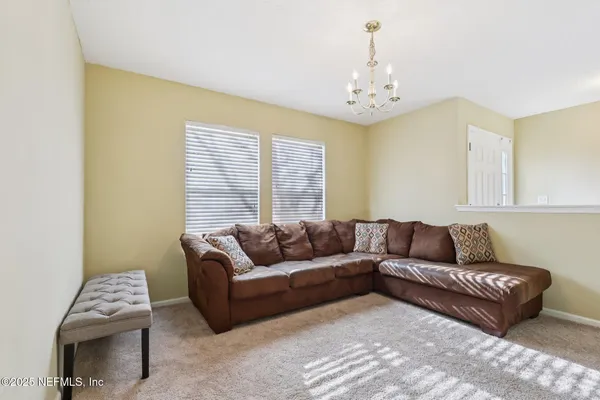 a living room with furniture and a chandelier