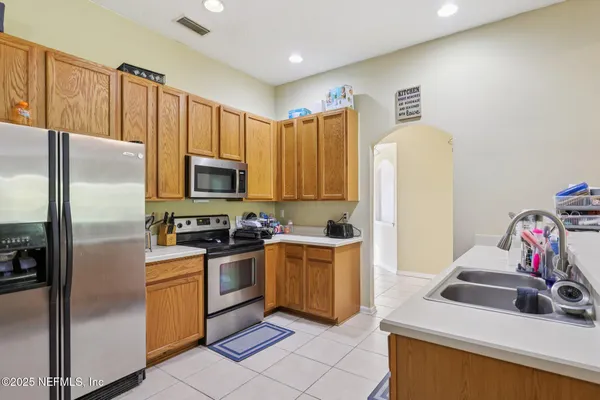a kitchen with a sink a refrigerator and a stove top oven