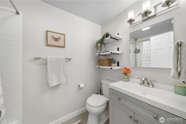 a bathroom with a granite countertop sink mirror vanity and toilet