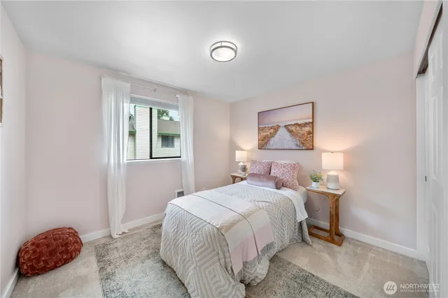 a bedroom with a bed and a lamp on the dresser