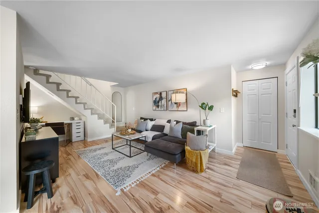 a living room with furniture and a wooden floor