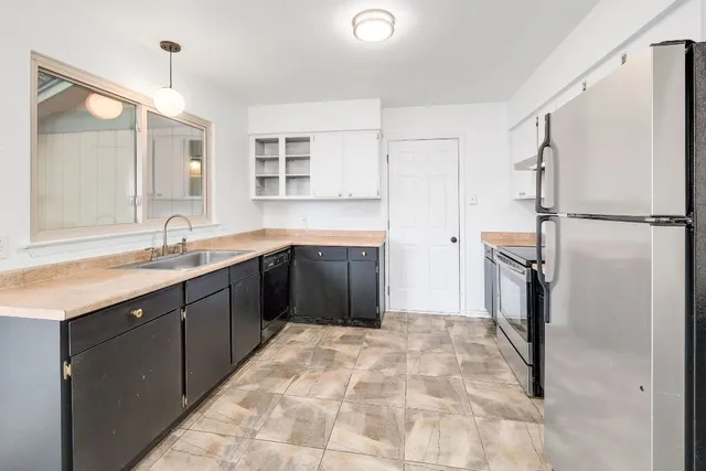 a kitchen with stainless steel appliances granite countertop a refrigerator sink and stove