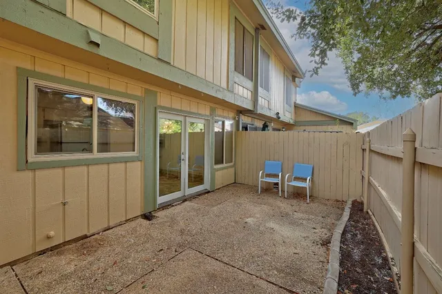 a view of a backyard with wooden fence and a large tree