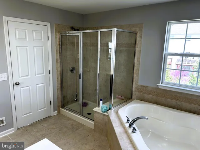 a bathroom with a tub shower and sink
