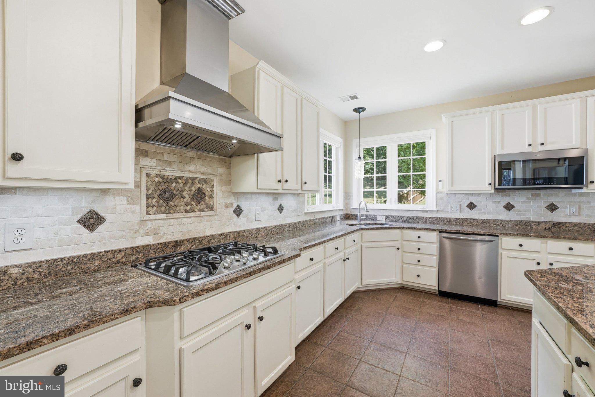 3679 Expedition Drive Triangle, VA 22172 - Photo 19 of 65 a kitchen with granite countertop stainless steel appliances sink stove and cabinets