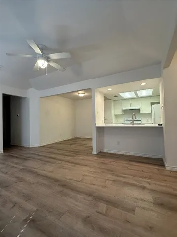 a view of an empty room and kitchen view