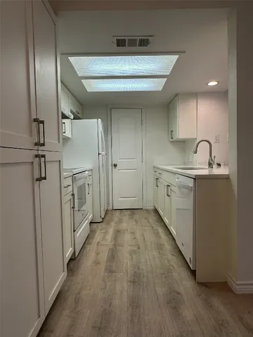 a kitchen with cabinets and wooden floor