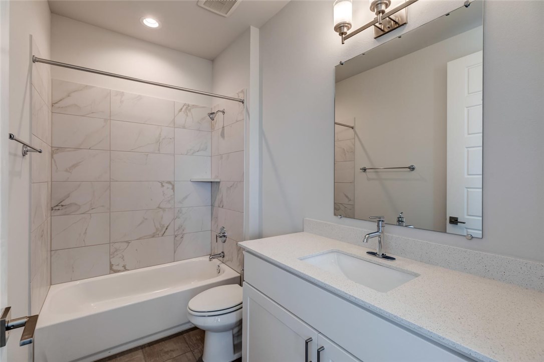 4600 Freedom Drive Austin, TX 78731 - Photo 26 of 40 a bathroom with a granite countertop sink a toilet and bathtub