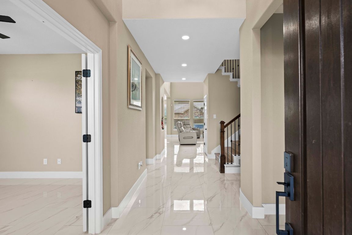 3301 Falconers Way Pflugerville, TX 78660 - Photo 13 of 39 Hallway featuring light marble finish floors, recessed lighting, and stairs
