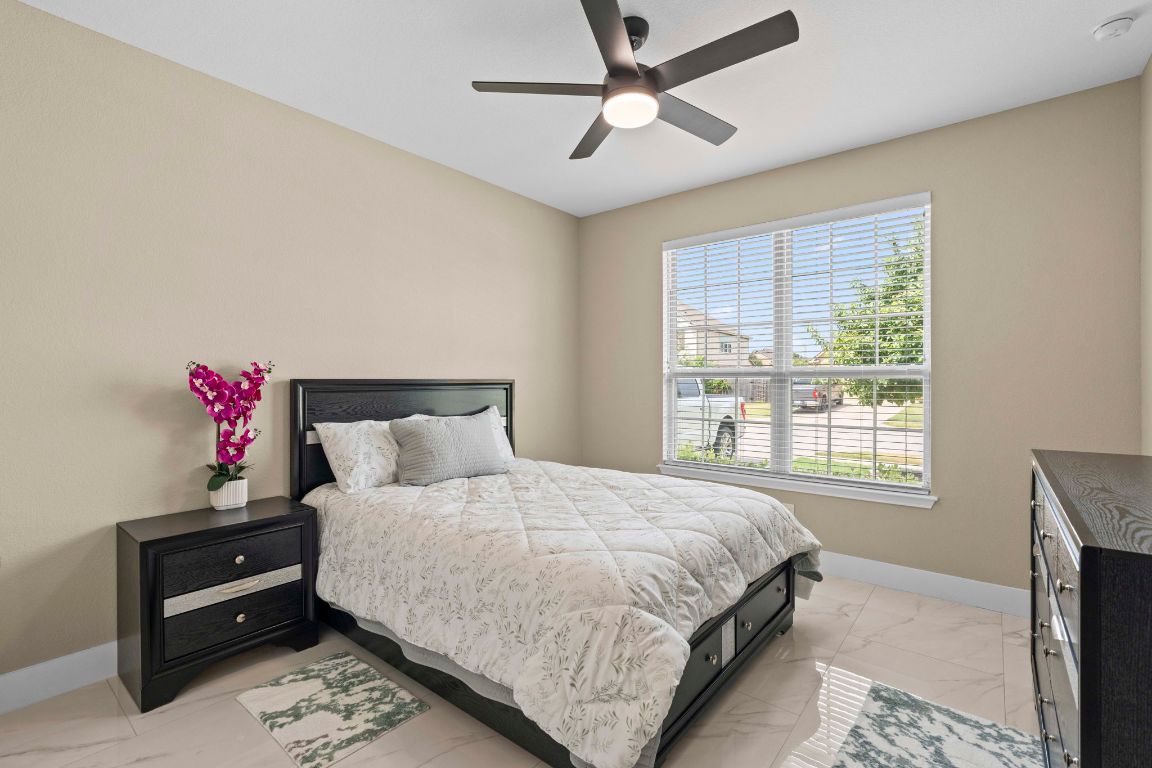 3301 Falconers Way Pflugerville, TX 78660 - Photo 14 of 39 Bedroom featuring light marble finish flooring and a ceiling fan