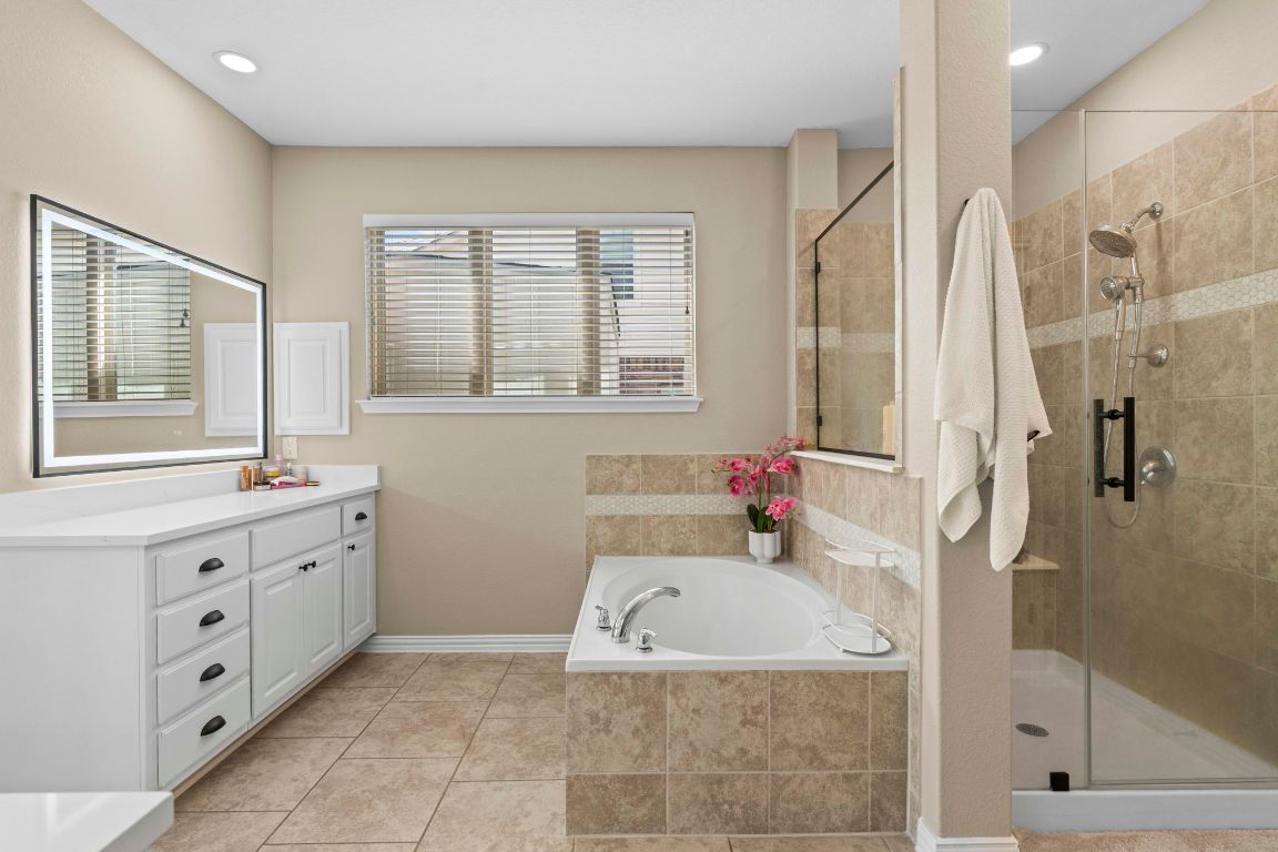 3301 Falconers Way Pflugerville, TX 78660 - Photo 29 of 39 Bathroom with a garden tub, vanity, a stall shower, recessed lighting, and light tile patterned flooring