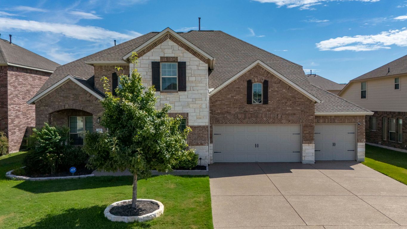 3301 Falconers Way Pflugerville, TX 78660 - Photo 3 of 39 View of front of home with brick siding, a front yard, stone siding, and concrete driveway