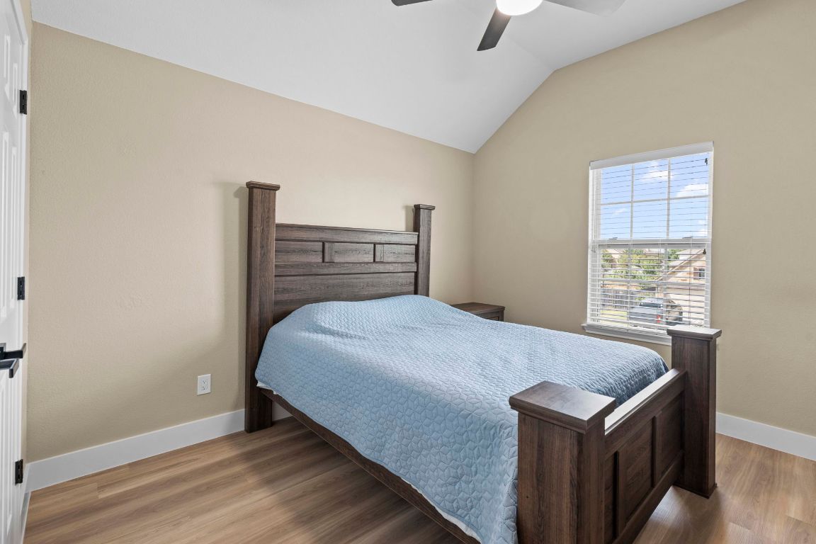 3301 Falconers Way Pflugerville, TX 78660 - Photo 31 of 39 Bedroom with vaulted ceiling, wood finished floors, and ceiling fan