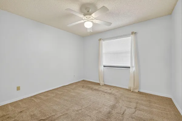 an empty room with chandelier fan