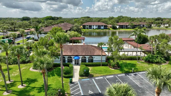 an aerial view of a house with a garden and lake view