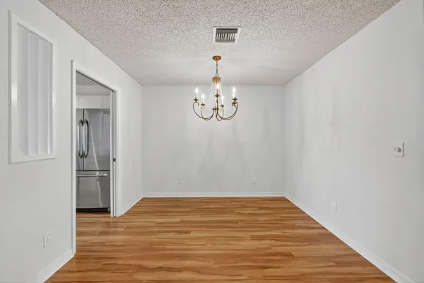 a view of a room with wooden floor and white walls